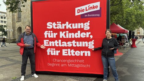 Sören Pellmann und Sonja Lemke stehen vor einem aufgeblasenen Würfel mit der Aufschrift: Stärkung für Kinder, Entlastung für Eltern